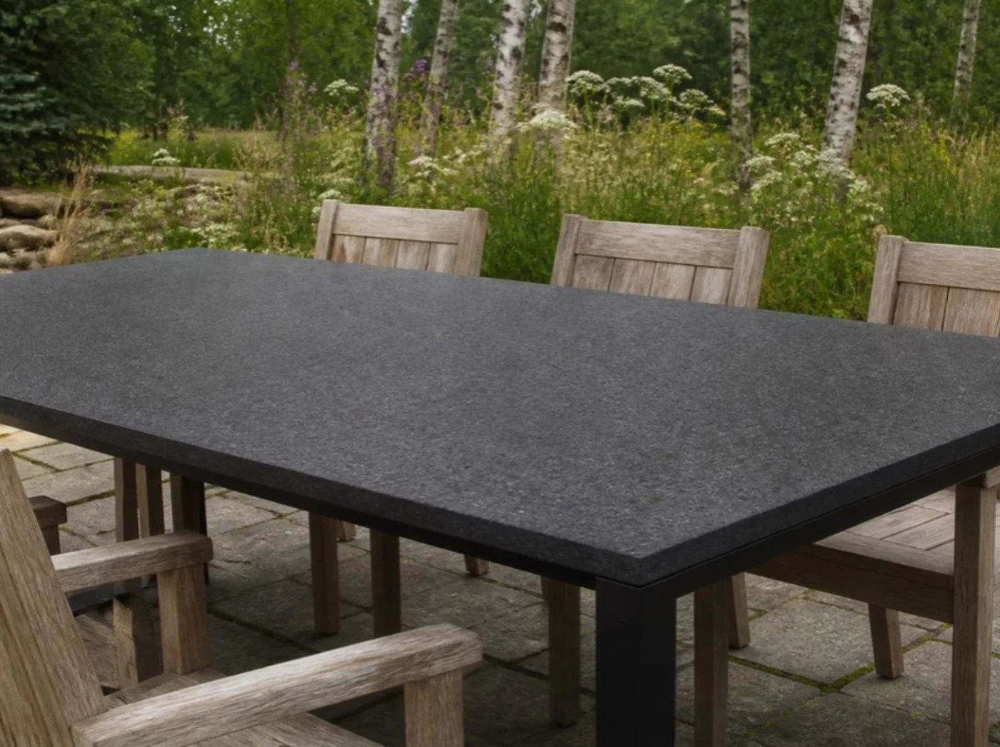Gartentisch mit Tischplatte aus Nero Impala Granit geflammt im Garten